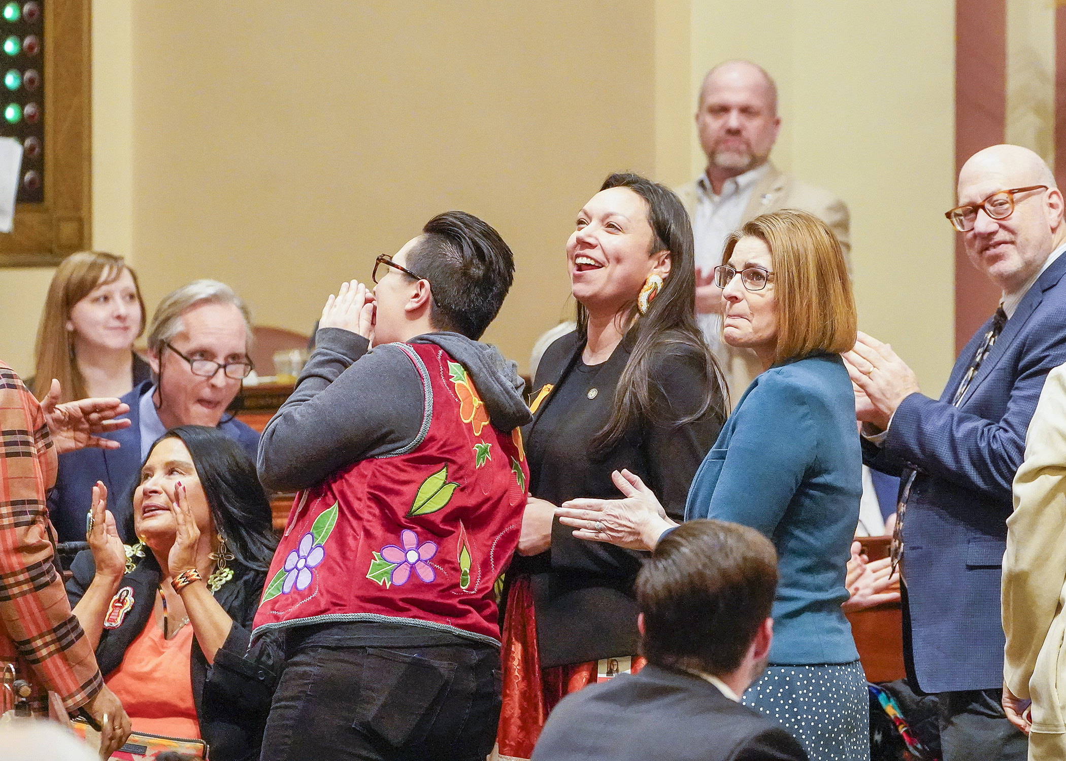 There was bipartisan celebration Thursday evening after a bill that would make changes to the Minnesota Indian Family Preservation Act, sponsored by Rep. Heather Keeler, center, passed 128-0. (Photo by Andrew VonBank) 